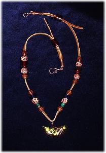 This clay handmade necklace is hand-painted in antique bronze, silver and gold. Accented w/glass beads, metal and clay handmade beads. Gold plated wire and posts are  used for final details. Unique Design and Very wild!