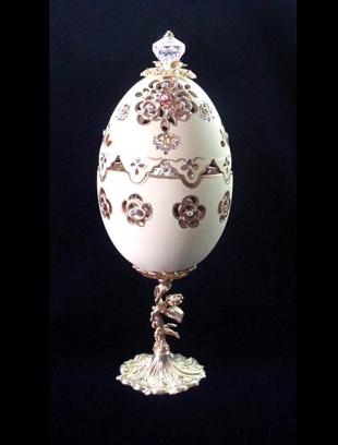 Painted in matte light yellow and gold enamel details. Top opens. Inside, a porcelain butterfly accented w/glitter and Austrian Crystals, rest on porcelain roses in pastels colors. Accented w/AB, amethysts and gold Austrian Crystals. 18K gold plated stand and findings. Glorious music inside as a final element. Decorated box available for this eggypiece. 