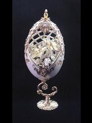 White Gala Eggypiece- Painted in pearl ivory and gold enamel details. Accented with medium size AB Austrian Crystals. Top is movable. Completely and extremely delicate carved design. Inside, white porcelain roses embellish two gold plated butterflies. 18K gold plated stand and findings. Very Elegant! Perfect for wedding gift. Decorated box available for this eggypiece.